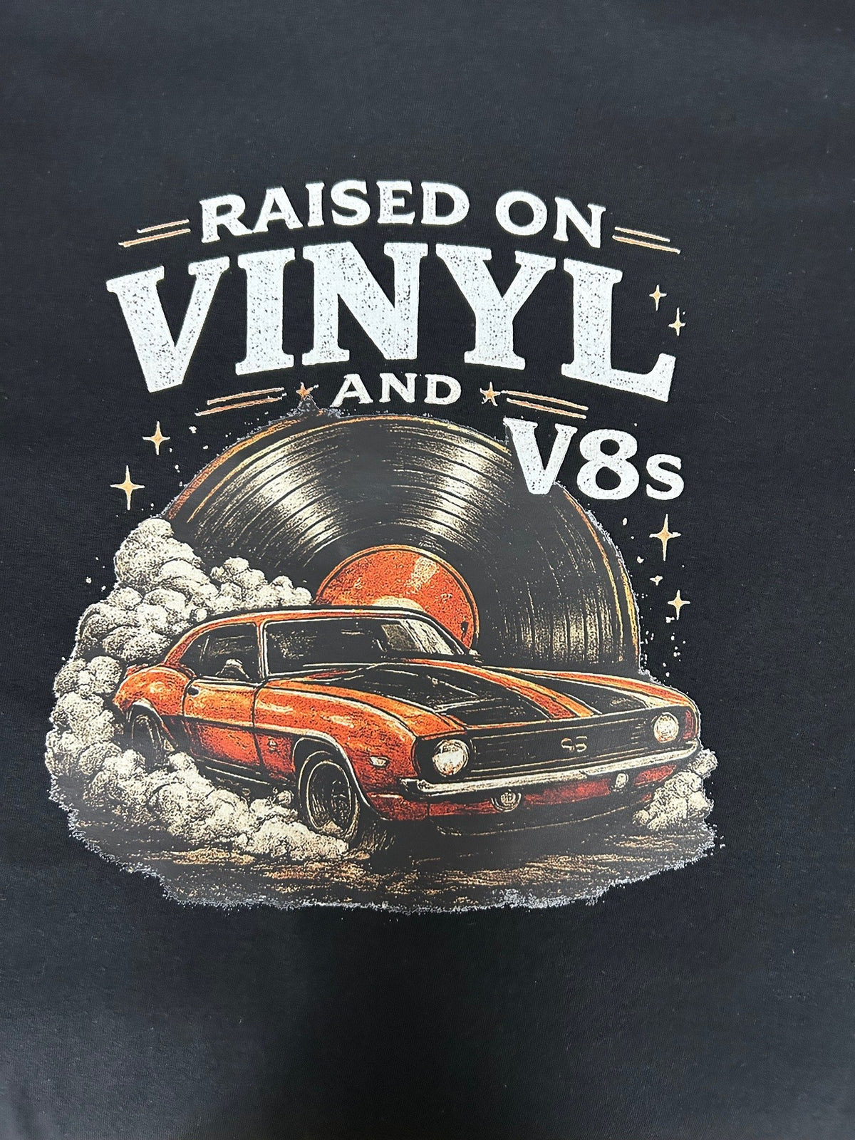 Close-up of the Raised On Vinyl and V8s print on a black t-shirt