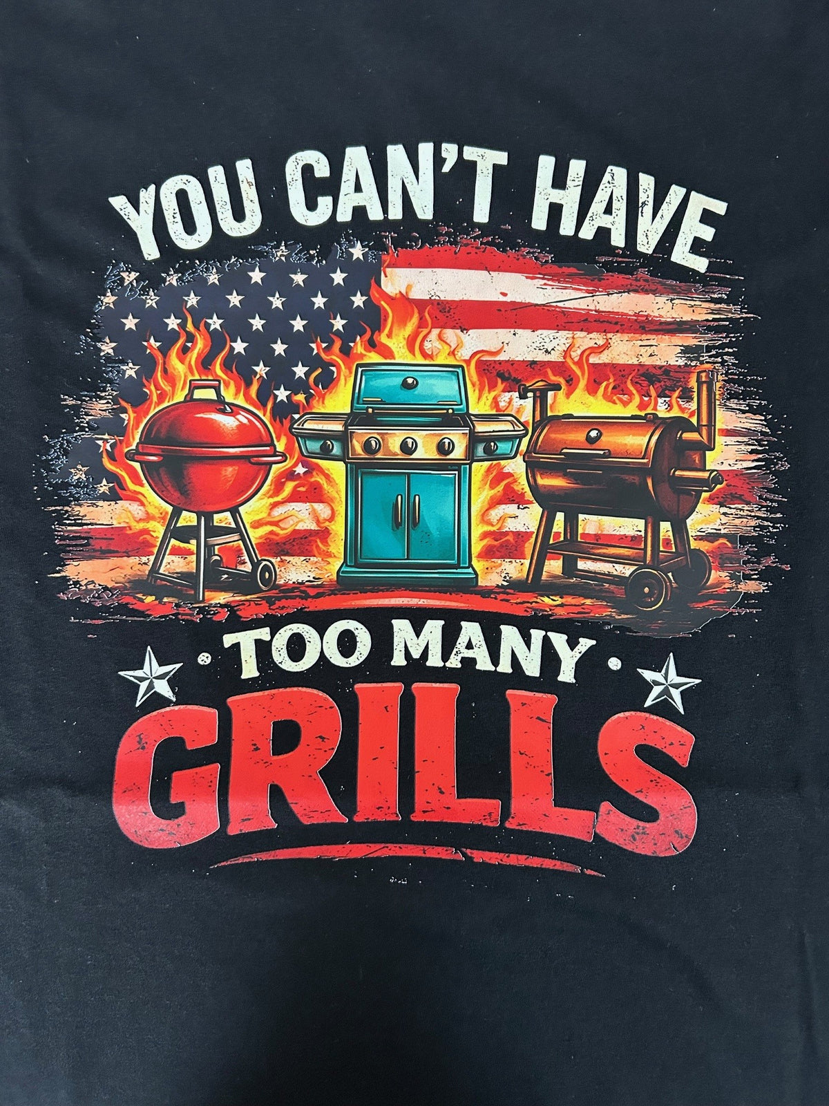 Close-up of the You Can't Have Too Many Grills print on a black t-shirt
