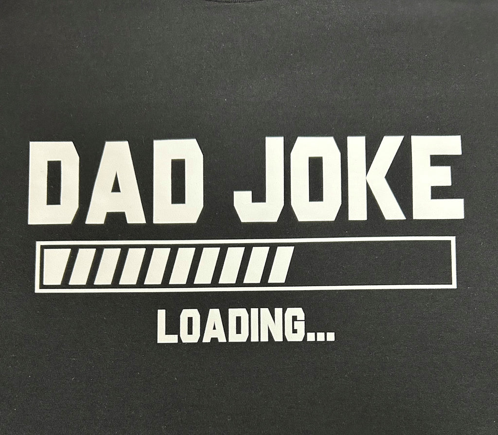 Close-up of the Dad Joke Loading print on a black t-shirt