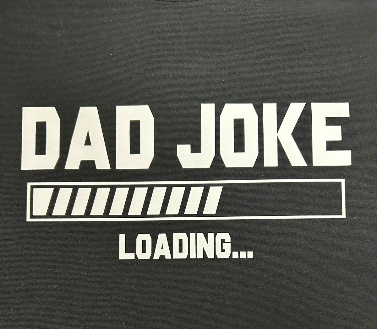 Close-up of the Dad Joke Loading print on a black t-shirt