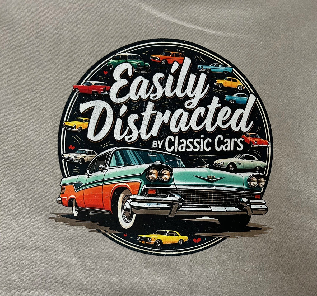 Close-up of the Easily Distracted By Classic Cars badge print on a gravel grey t-shirt