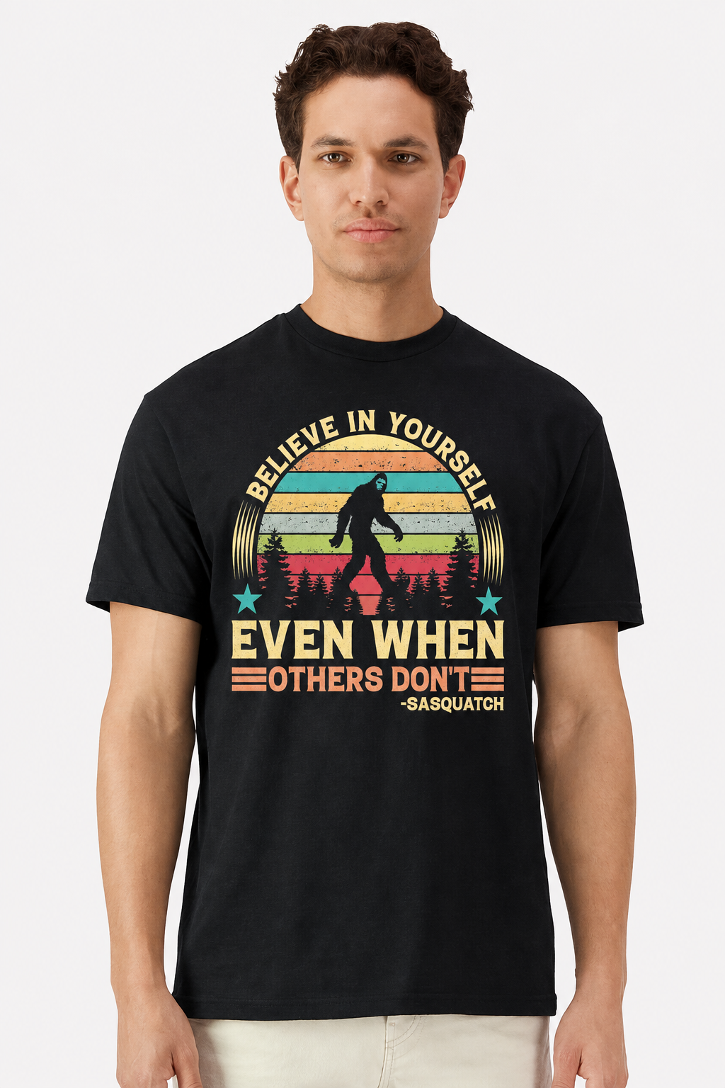 Model wearing a black t-shirt with a retro sunset Believe In Yourself Sasquatch print